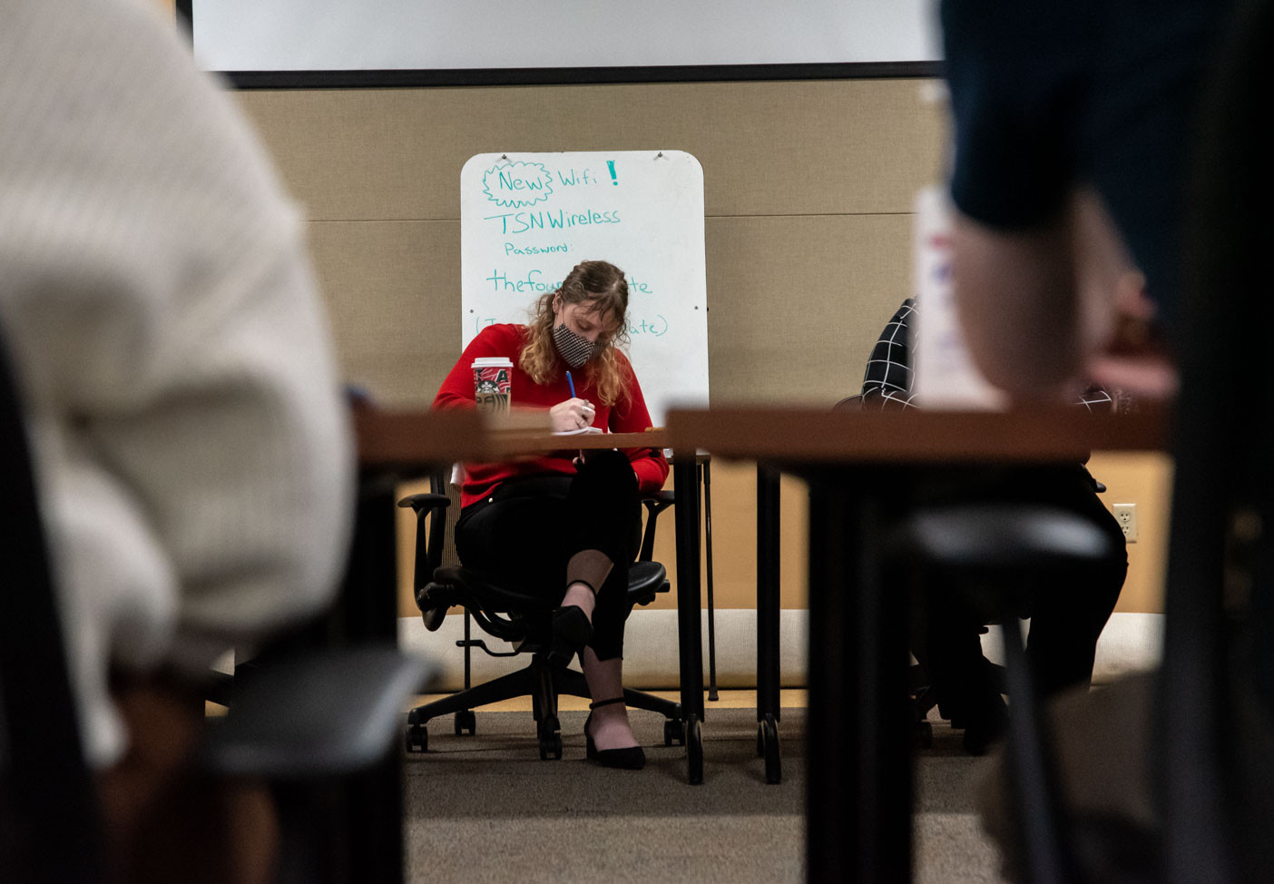 Karly Graham writing notes during an interview with President Stanley.