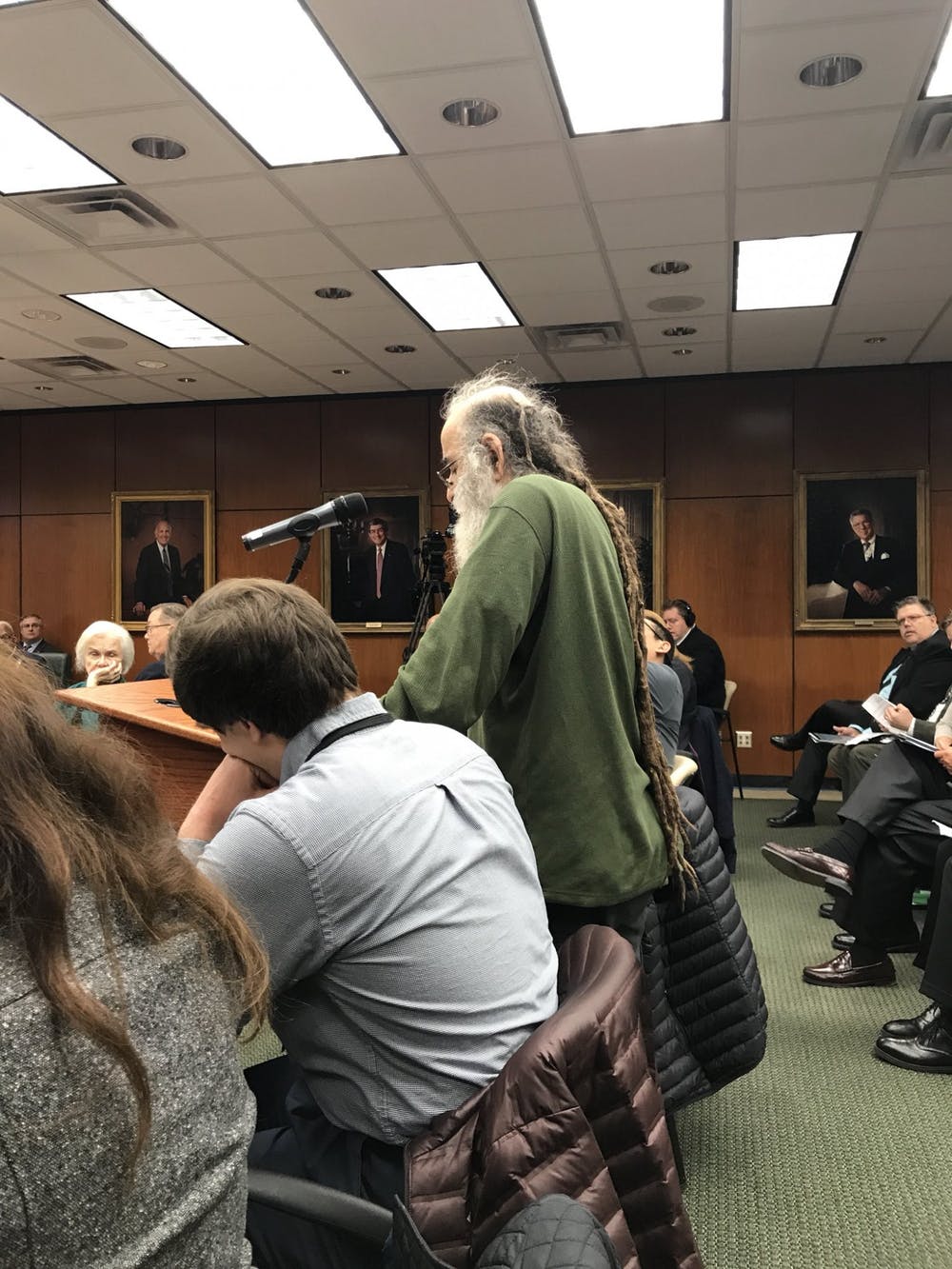 Former Professor Selman Akbulut stands at the podium at a Michigan State University Board of Trustees meeting.