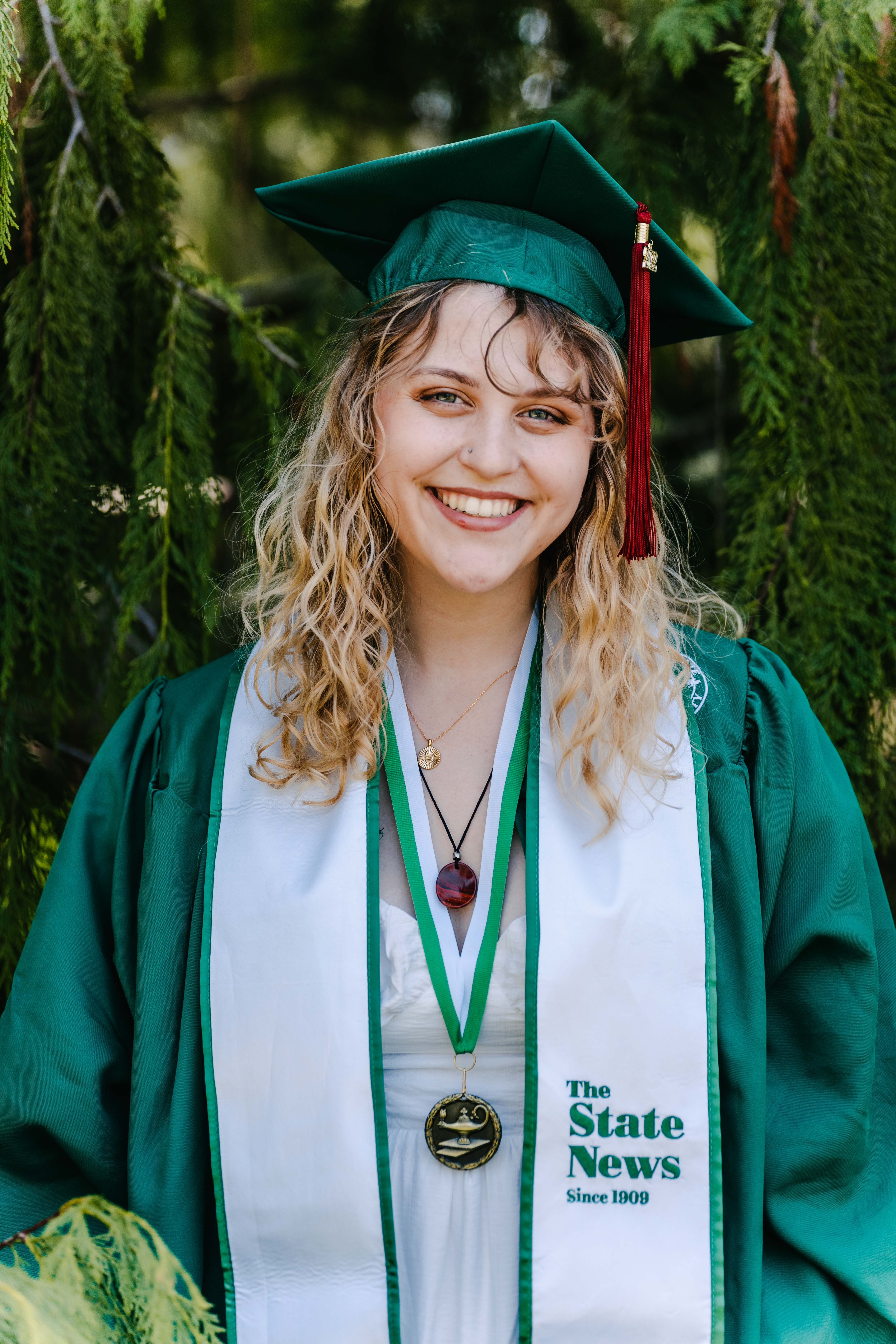 Karly Graham smiling in a cap and gown on Michigan State University's campus.